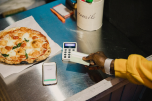 client en train de régler sa pizza